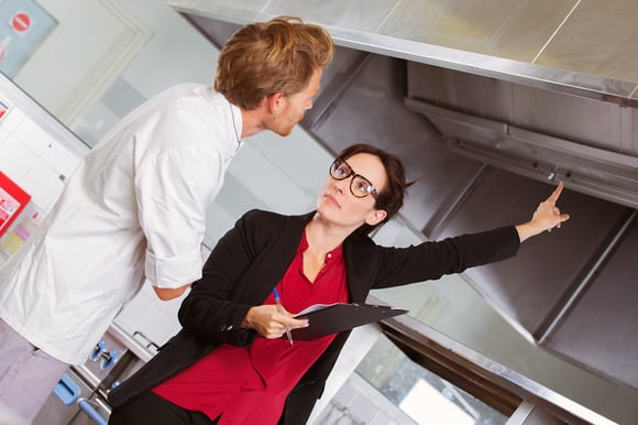 Manager pointing out issue to kitchen staff
