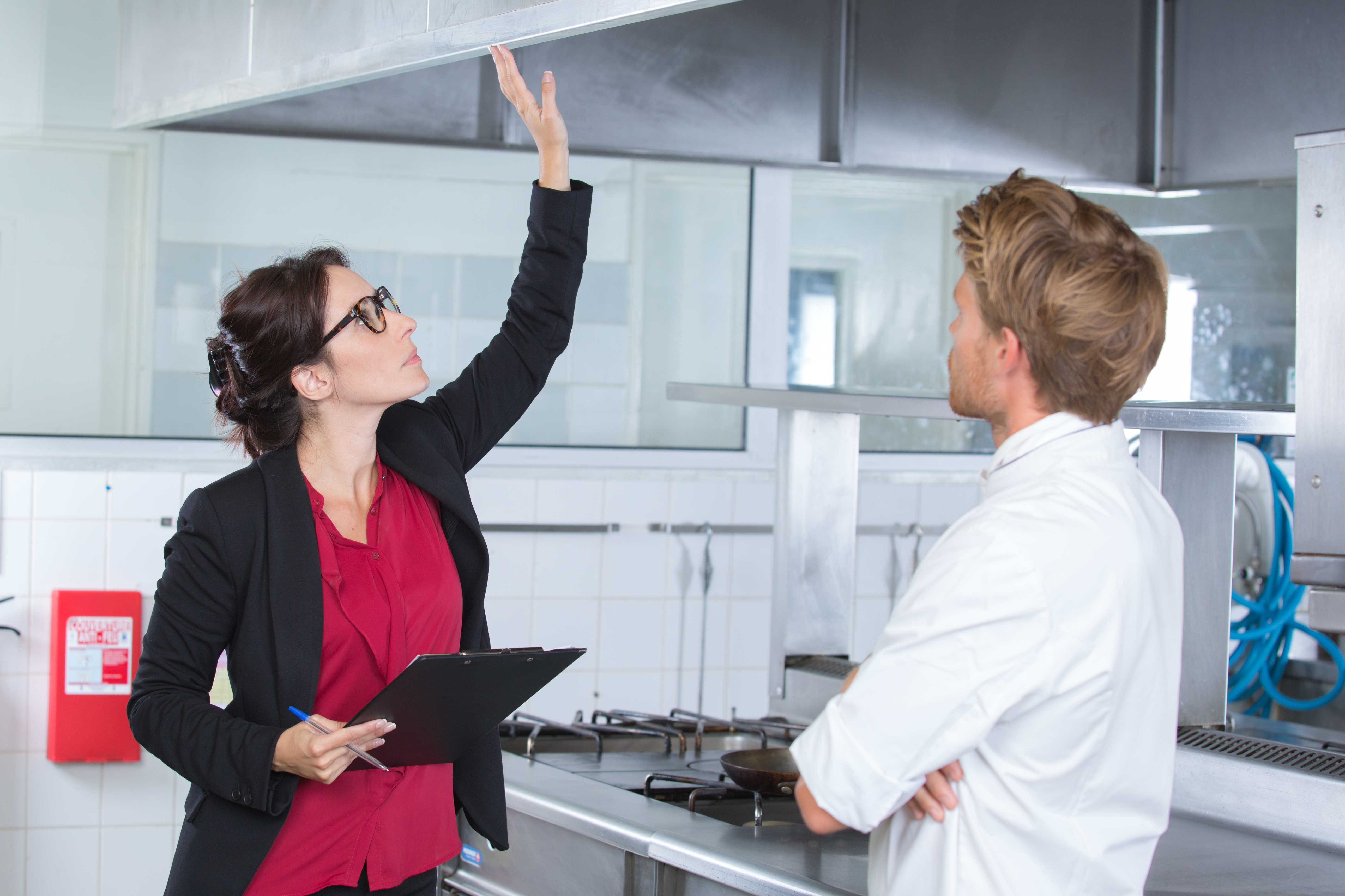 Manager reviewing kitchen equipment